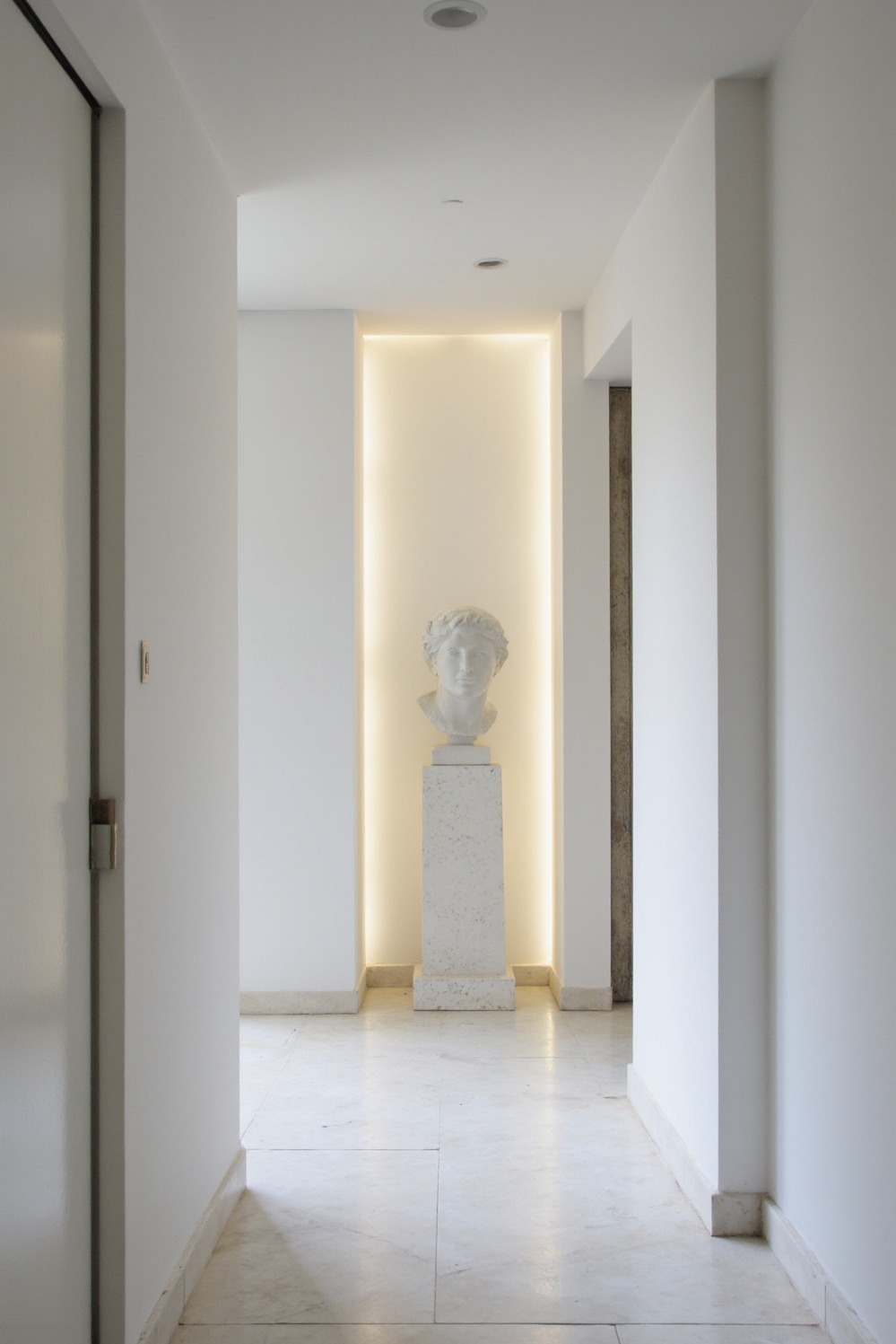 end of hallway decor - Architectural Elegance at the Hallway’s End - A plaster niche with integrated lighting...