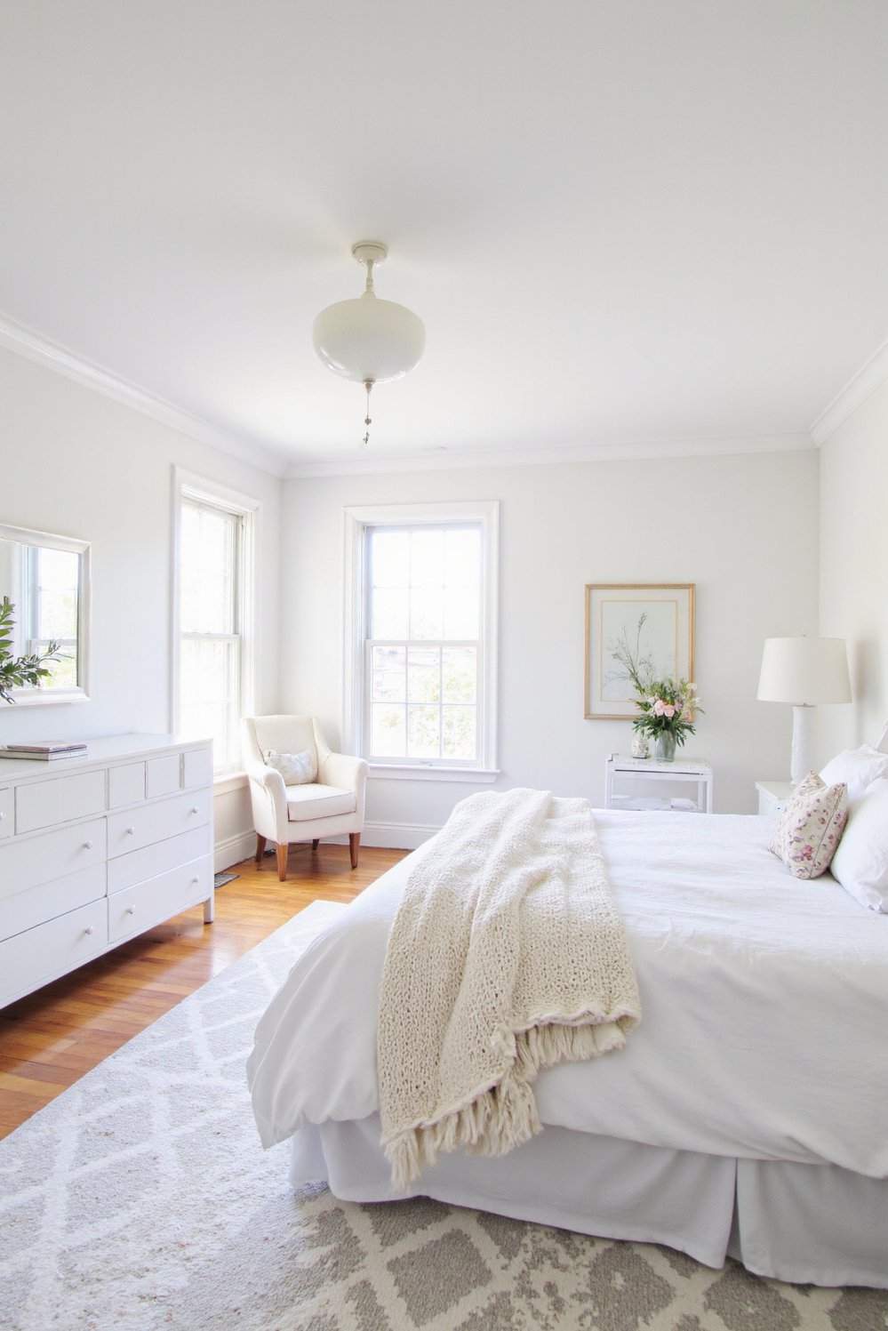 White bedroom decor ideas - Expansive White Bedroom: Bold Patterns and Crisp Fabrics - Spacious white bedroom with geometric rug