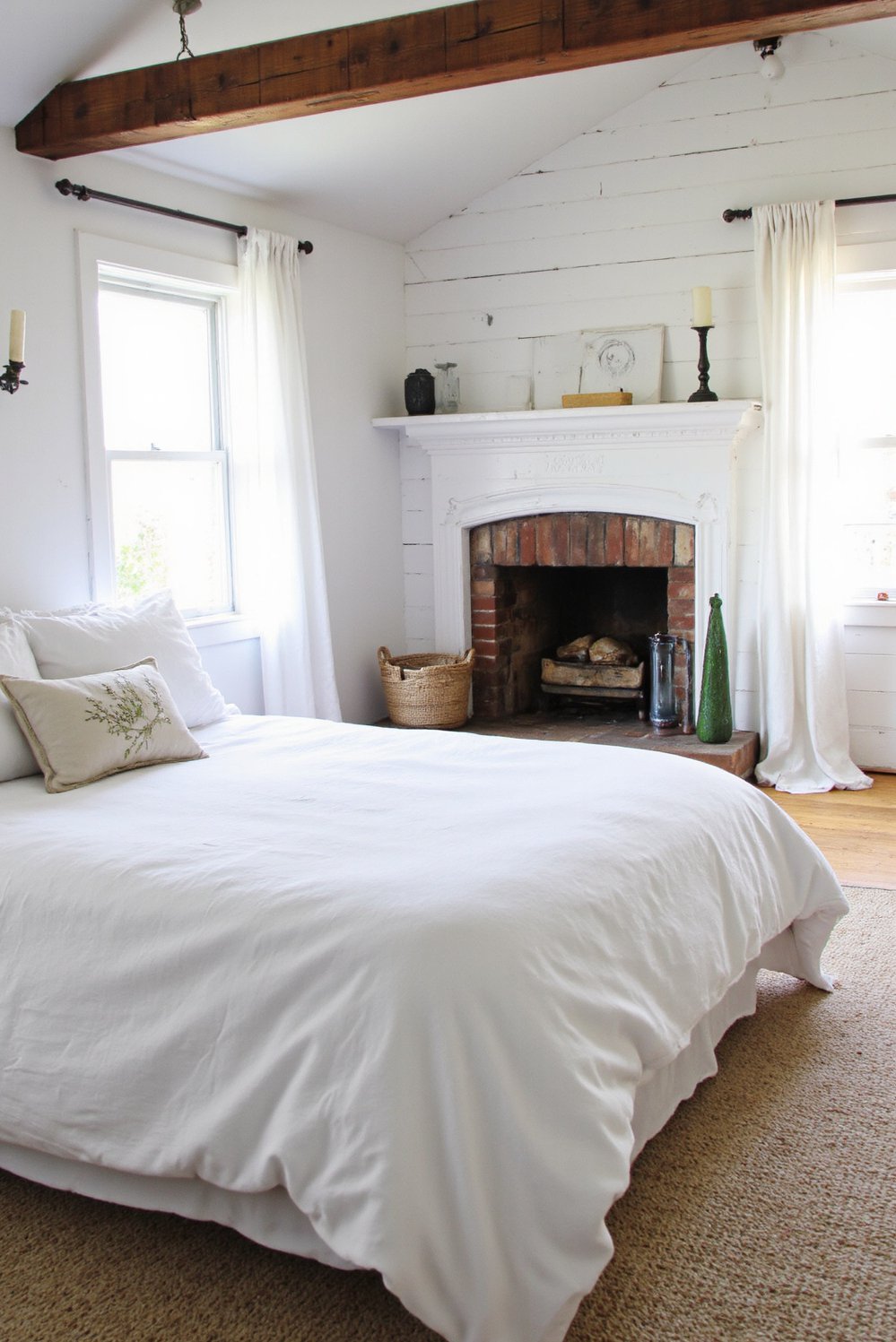 White bedroom decor ideas - Farmhouse White Bedroom: Rustic Textures and Soft Whites - Cozy farmhouse bedroom with whitewashed brick