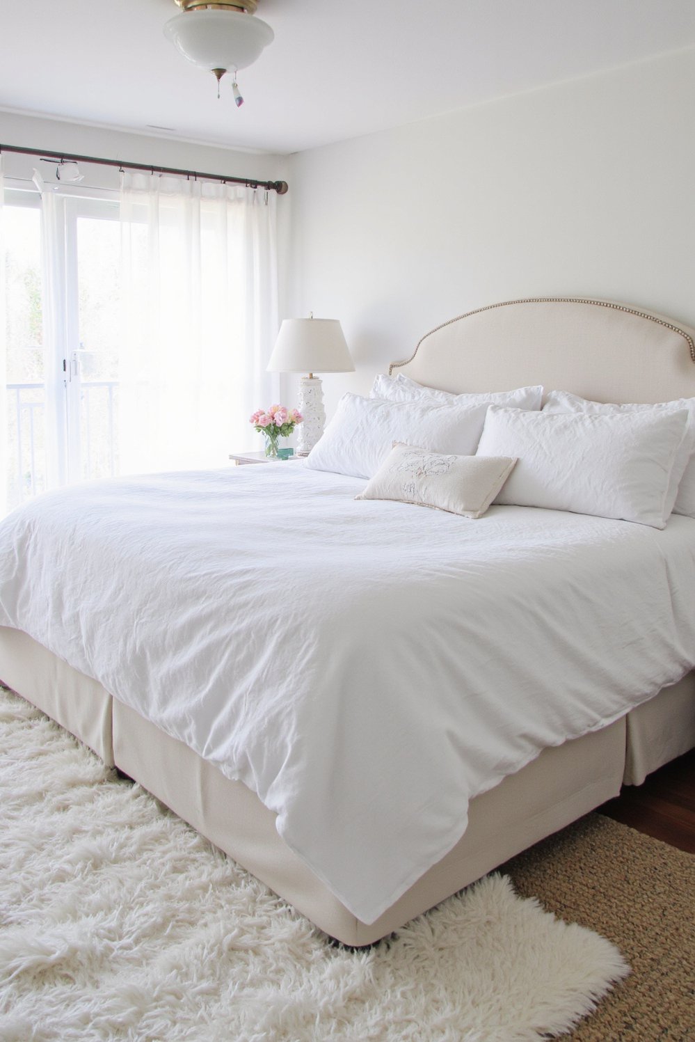 White bedroom decor ideas - Sumptuous Comfort: Plush Bedding and Spacious Beds - White bedroom with king-size bed and fluffy rug