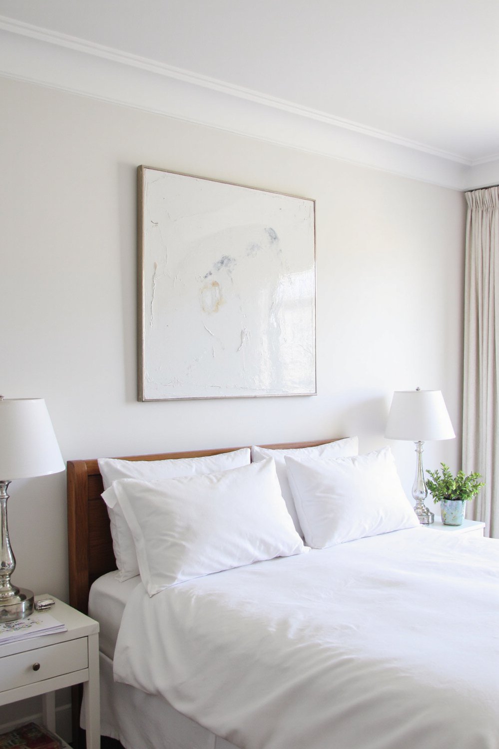 White bedroom decor ideas - Artful Whites: Statement Pieces and Cozy Ambiance - White bedroom with bold artwork