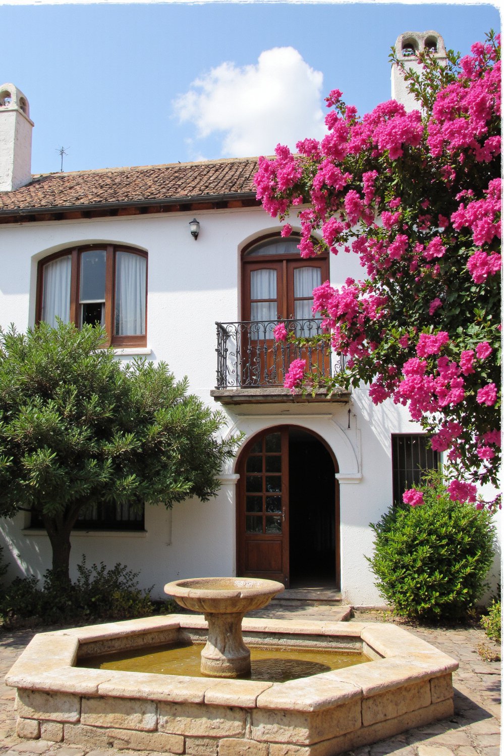 Italian villas exteriors - Spanish-Influenced Villa: Clay Roof and Ornate Ironwork - Spanish style villa with vibrant bougainvillea…