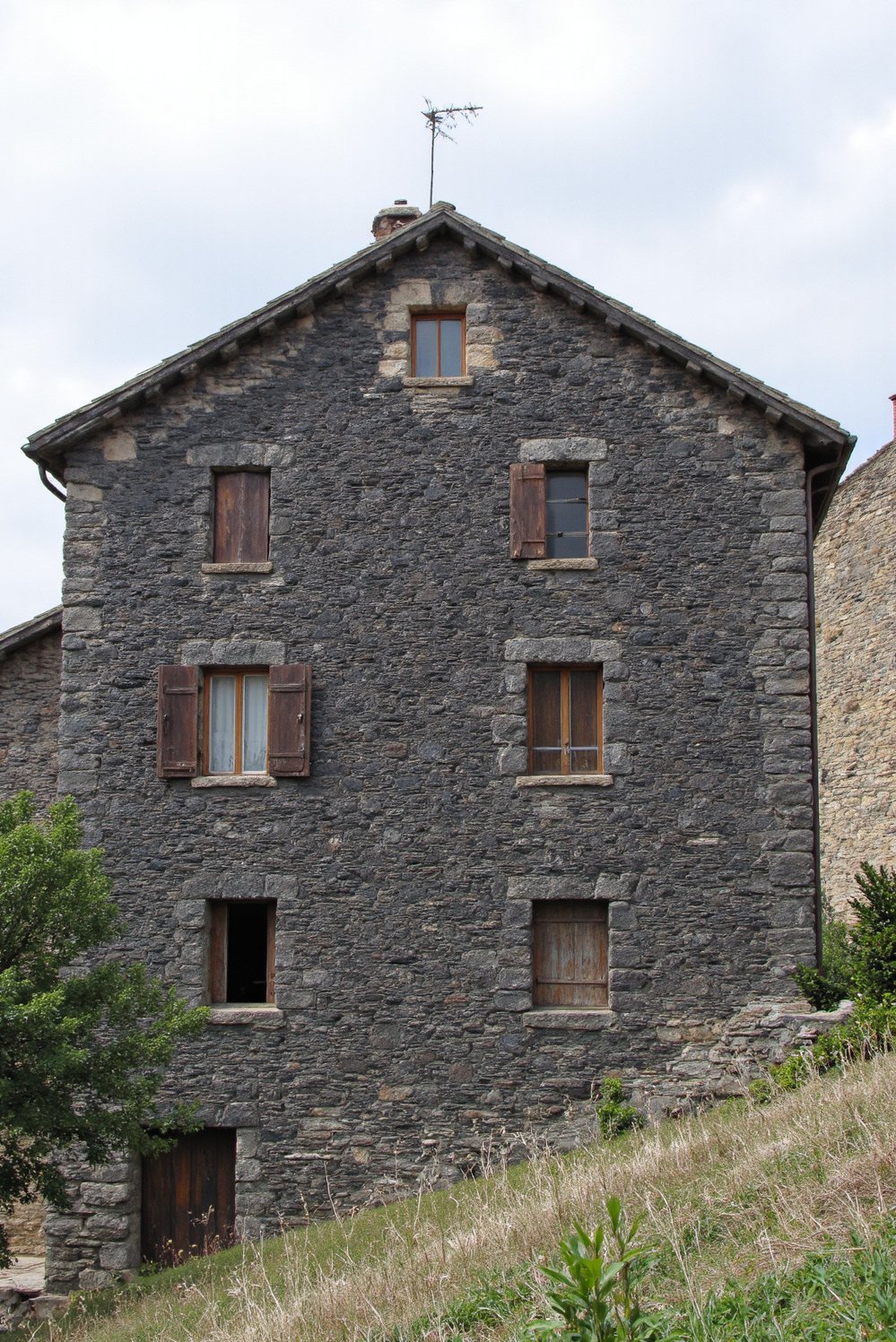Italian villas exteriors - Rustic Stone House: Steep Roof and Deep-Set Windows - Tuscan stone home with strong architectural lines…