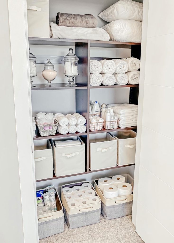 Linen closet with soft neutrals and organized bins